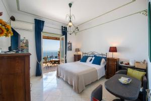 1 dormitorio con 1 cama, mesa y sillas en Amalfi Residence, en Conca dei Marini