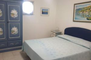 1 dormitorio con 1 cama y una pintura en la pared en Apartment with garden in Pianoconte -Lipari, en Lipari
