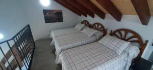 een kamer met 2 bedden in de hoek van een kamer bij El Molino 2 in Muros de Nalón