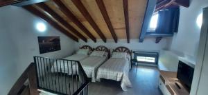 ein Schlafzimmer mit einem Bett und einem TV in einem Zimmer in der Unterkunft El Molino 2 in Muros de Nalón