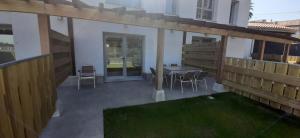 een terras met een tafel, stoelen en een hek bij El Molino 2 in Muros de Nalón