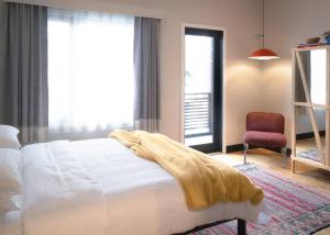 a bedroom with a white bed and a red chair at Elegant Townhouse, Hudson center, 3 ensuite baths in Hudson