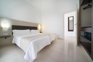 1 dormitorio con 1 cama blanca grande en una habitación en LABRANDA Bahía Fañabé & Villas, en Adeje