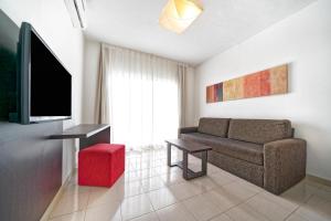 een woonkamer met een bank en een flatscreen-tv bij LABRANDA Bahía Fañabé & Villas in Adeje