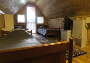 ein Schlafzimmer mit einem Bett und einem TV in einer Hütte in der Unterkunft Mazurówka Romana in Spychowo