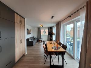 Un comedor con una mesa y una sala de estar. en Strandkajüte Hooksiel, en Wangerland