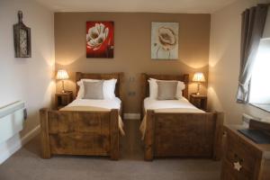 a bedroom with two beds and two lamps in it at The Woodman Inn in Bedale