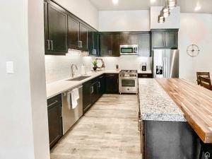 cocina con armarios negros y encimera de madera en Beautiful Brand NEW Luxury Condo @ Sage Creek, en Moab