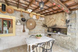 eine Küche mit einem Tisch und einer Steinmauer in der Unterkunft Casa Liori in Dolianova
