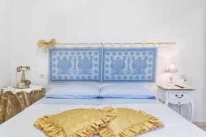 Bett mit blauem Kopfteil und gelbem Kissen in der Unterkunft Casa Liori in Dolianova