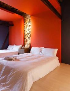 - une chambre avec 2 lits et un mur orange dans l'établissement How Has Homestay, à Chishang