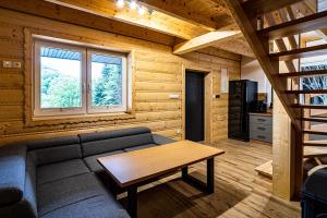 een woonkamer met een bank en een tafel bij UROCZYSKO-POLAŃCZYK Prywatne Jacuzzi i Sauna w cenie !!! in Polańczyk