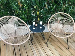 2 sillas y una mesa con una botella de vino en LA ROMANTIQUE SPA en Saint-Avertin
