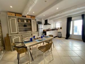a kitchen with a table and chairs in a room at Appartement La maison du pêcheur in Sainte-Maxime +8 photos
