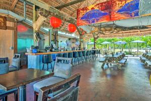 a restaurant with a bar with tables and chairs at Everglades Rental Trailer Cabin with Boat Slip! in Everglades City