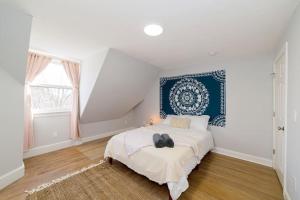 een slaapkamer met een bed met een blauw hoofdeinde bij Sunshine Central - Yale 3BR Prking Wshr/Dryr in New Haven