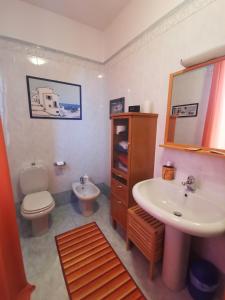 a bathroom with a sink and a toilet and a mirror at B&B La Casa del Barbiere in Albareto