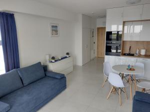 a living room with a blue couch and a table at 4 Sosny Porta Mare in Dziwnówek