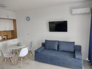 a living room with a blue couch and a table at 4 Sosny Porta Mare in Dziwnówek