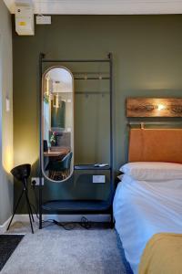 1 dormitorio con espejo junto a la cama en The Old Laundry eco annex w free parking en Norwich