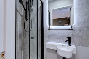 La salle de bains est pourvue d'un lavabo et d'une douche. dans l'établissement The Old Laundry eco annex w free parking, à Norwich
