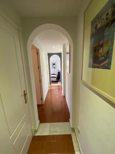 um corredor com uma arcada numa casa em Alcaudón 1 dormitorio by SIT ISLA CANELA na Isla Canela