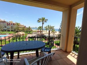 uma varanda com mesa e cadeiras e vista para a praia em Alcaudón 1 dormitorio by SIT ISLA CANELA em Isla Canela