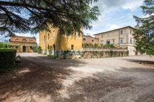 ein großes gelbes Gebäude mit Bäumen davor in der Unterkunft Tinaia in Siena
