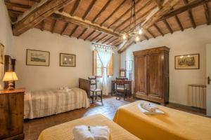 ein Hotelzimmer mit 2 Betten und einem Schreibtisch in der Unterkunft Tinaia in Siena