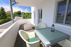 a table and chairs on a balcony with a view at Villa Vineta Whg. 12 mit Südbalkon in Göhren