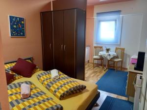 1 dormitorio con 1 cama, armario y mesa en D,apartman en Omišalj