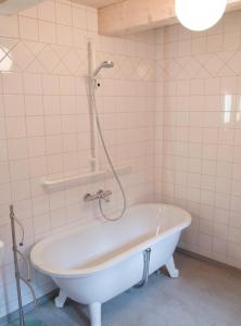 eine Badewanne im gefliesten Bad mit Dusche in der Unterkunft Das Ferienhaus Wernigerode - direkt "Am kleinsten Haus" von Wernigerode in Wernigerode