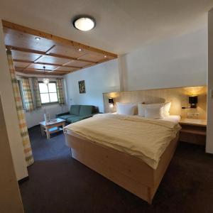 una camera con un grande letto e un soggiorno di Hof Unterhuben a Fügenberg