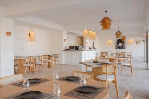 a dining room with tables and chairs and a kitchen at Trendlife Hotels Torba in Bodrum City