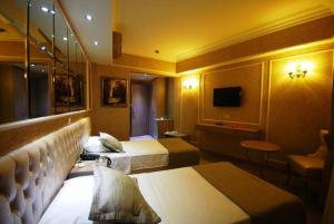 ein Hotelzimmer mit 2 Betten und einem TV in der Unterkunft deniz otel in Istanbul