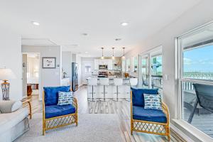 a living room with blue chairs and a kitchen at The Ridge in Rockport