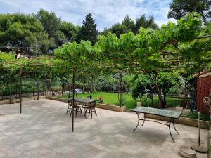 un patio con tavoli, sedie e alberi di Retreat Apartments with free parking a Pola (Pula)