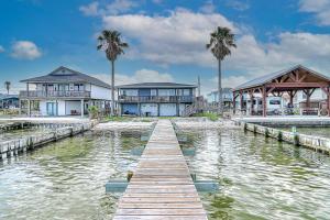 a dock in the water with houses and palm trees at The Ridge in Rockport