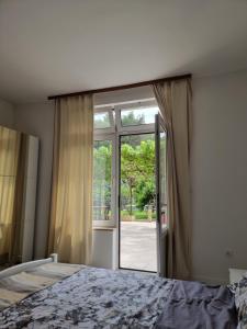 a bedroom with a bed and a sliding glass door at Retreat Apartments with free parking in Pula