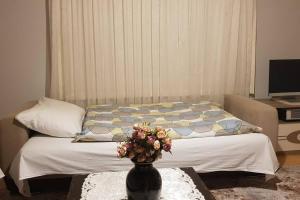 ein Schlafzimmer mit einem Bett und einer Vase mit Blumen auf dem Tisch in der Unterkunft Zigana* / Mountain Apartment at 2050 meters high in Torul