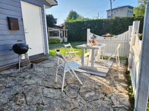 un patio con tavolo, sedie e griglia di Jannseni House a Pärnu