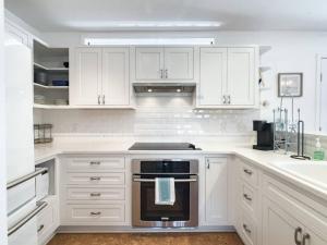 uma cozinha com armários brancos e um forno com placa de fogão em Perdido-Orange Beach, Golfing 2BR-2,5BT em Pensacola