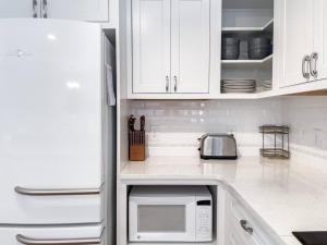 a kitchen with white cabinets and a microwave at Perdido-Orange Beach, Golfing 2BR-2,5BT in Pensacola
