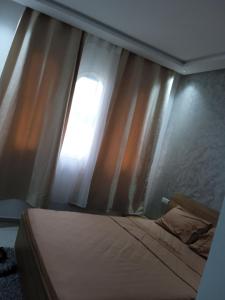 een slaapkamer met een bed en een raam bij Résidence lilia jabal mdiq in M'diq