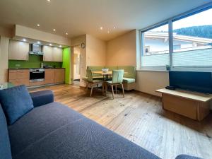 a living room with a couch and a table and a kitchen at Apartment Waldnah in Wenns