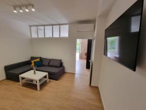 a living room with a couch and a table at Retreat Apartments with free parking in Pula