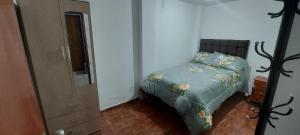 1 dormitorio con 1 cama con edredón verde en Real in House Cusco, en Cusco