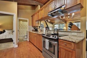 a kitchen with wooden cabinets and a stove top oven at Alpine Court Chalet home in Killington
