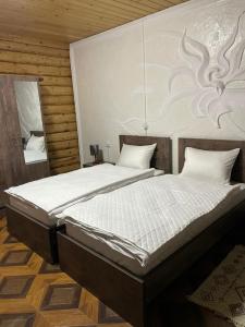 a bedroom with a large bed with white sheets at Grigoleti River Club in Maltakva