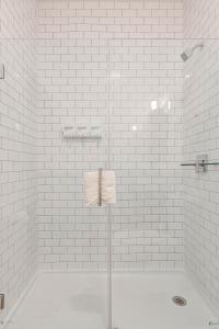a white bathroom with a shower with white tiles at Cabin 105 by 747 Lofts in Chicago